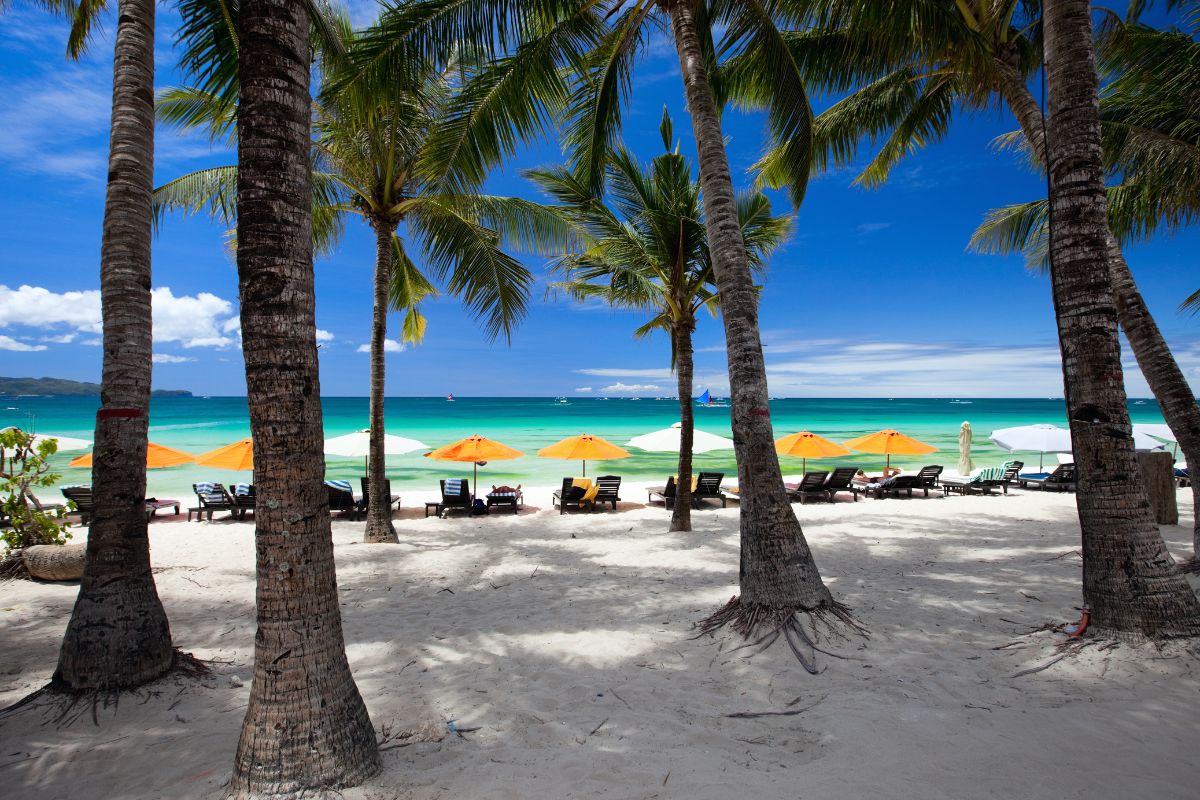 Sun loungers are empty in low season in front of hotels on Boracay beach