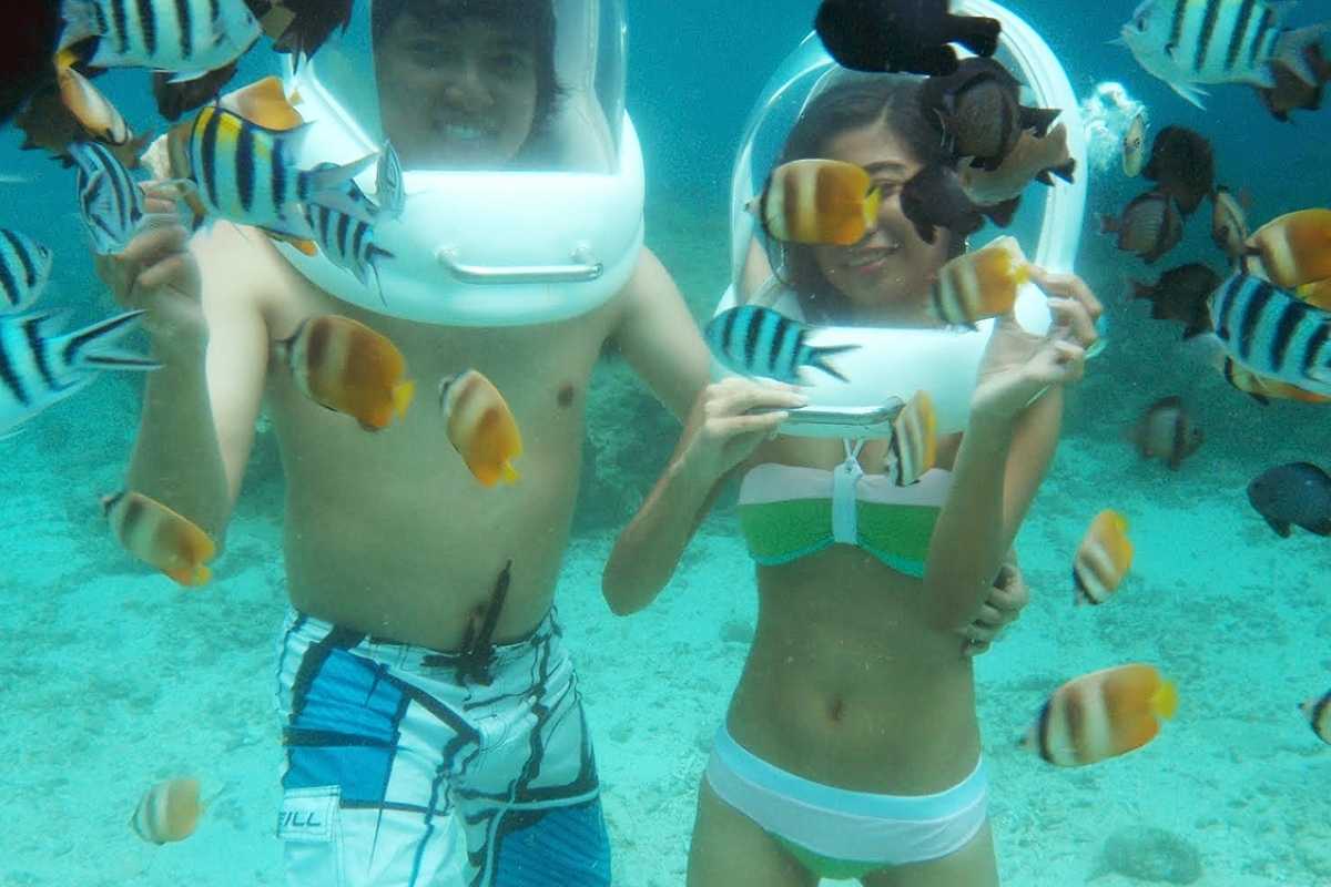 A couple enjoying helmet diving in the beautiful clear waters of Boracay