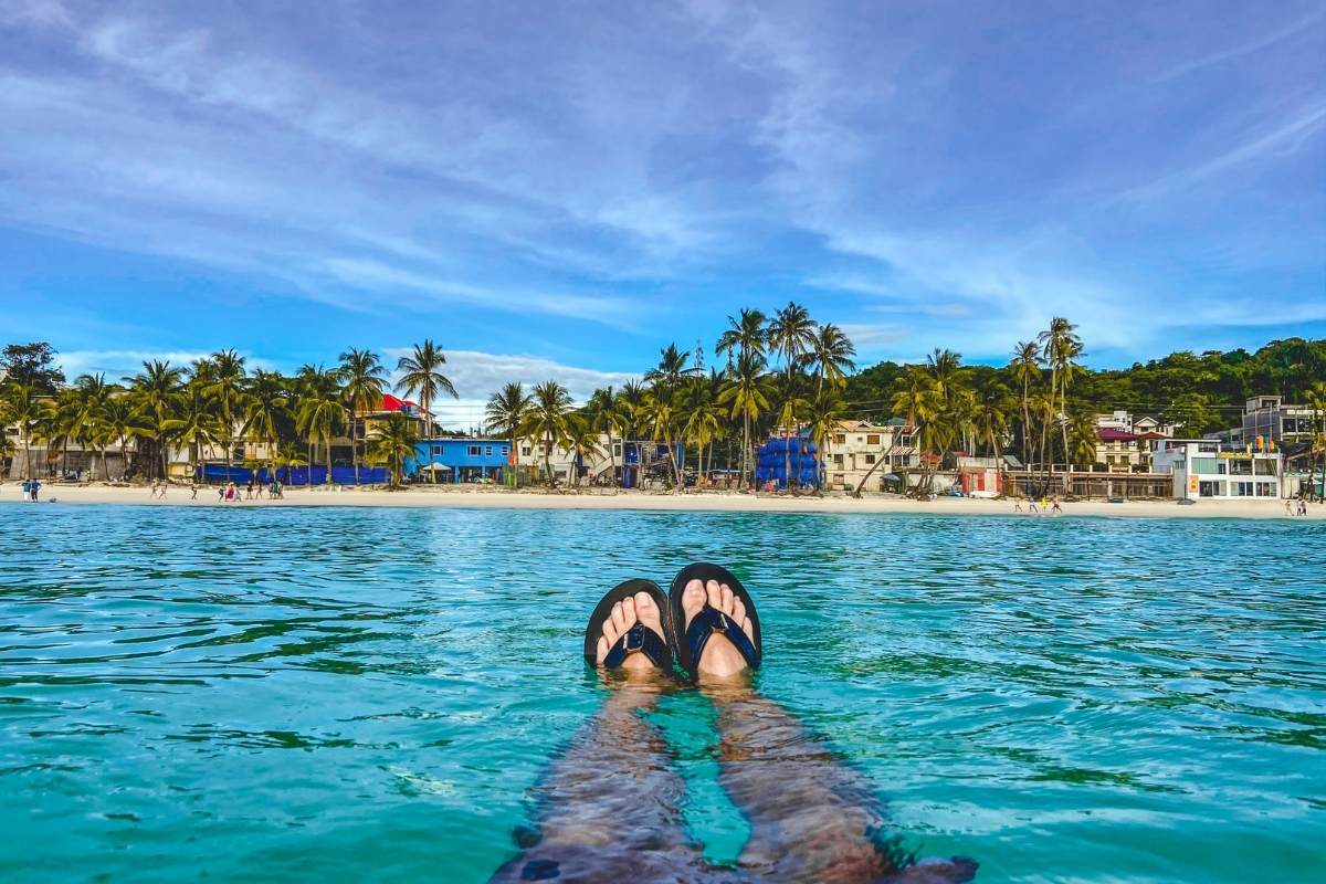 My friends feet swimming in Boracay Island looking back at Whites Beach