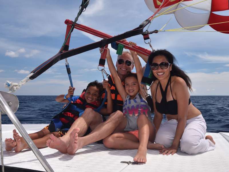 A family visiting Boracay just about to take off on a tandem parasail together